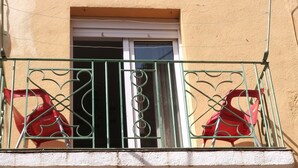 A balcony with a metal railing and two red plastic chairs. - Colera House Costa Brava (Colera)