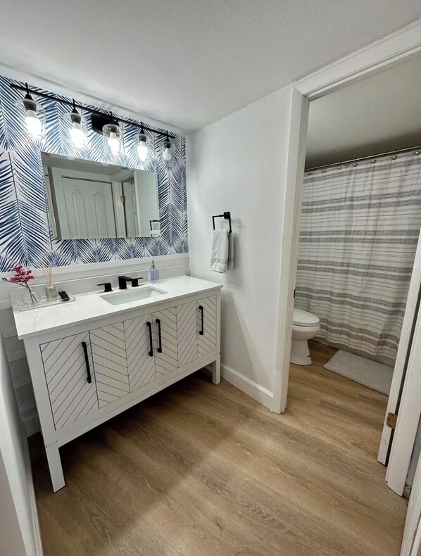 A bathroom with a white vanity, a mirror, and a shower curtain. - Siesta Key Beach Condo w/ water view & pool, half mile to the beach! (Siesta key)