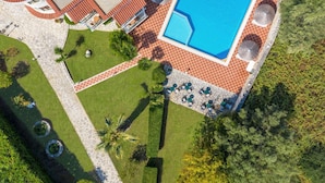 Vista aérea de un resort con piscina, mobiliario exterior y zonas ajardinadas.