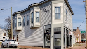 A corner building with the name 'Eileen' on the side, a storefront, and a parked truck.