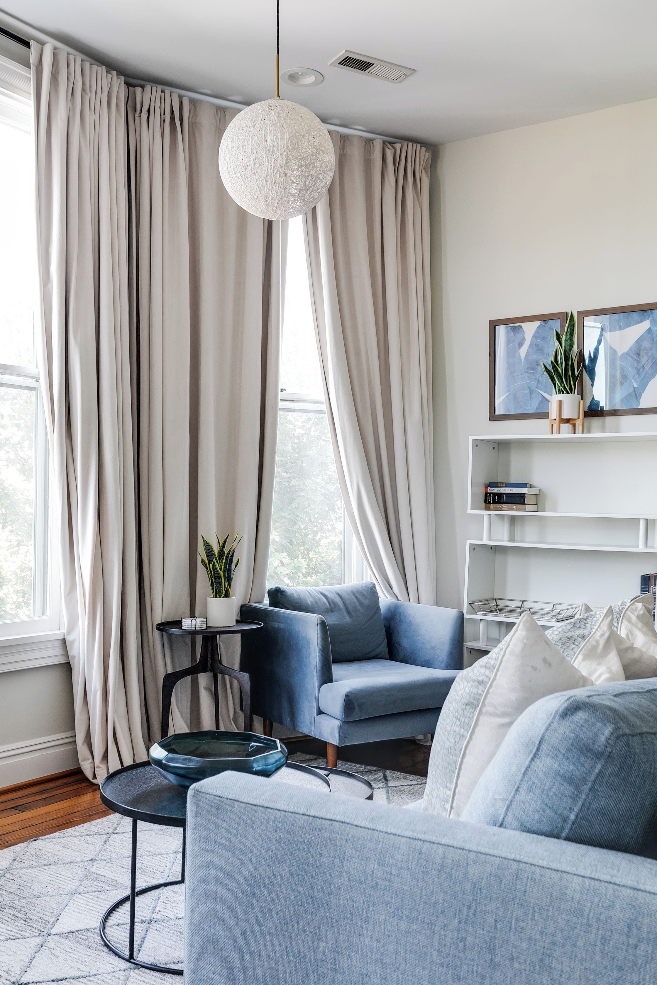 Een moderne woonkamer met een bank, een salontafel en een hanglamp.