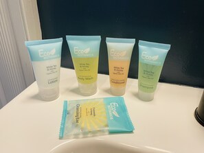 Four Eco Botanics products on a white sink: White Tea & Honey Lotion, White Tea & Honey Body Wash, White Tea & Honey Conditioner, and Nourishing Shampoo. - Newly Renovated, Spacious Suite with Every Luxury (Richmond)
