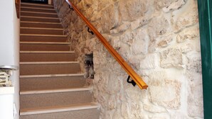 Eine Treppe mit einem Holzgeländer an einer Steinwand.