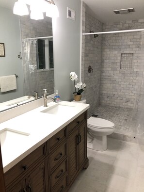 Een bad/douchecombinatie, handdoeken, toiletpapier