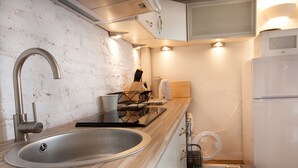 Una cucina moderna con lavello in acciaio inossidabile, forno integrato e frigorifero bianco.