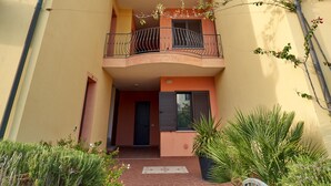 A two-story building with a balcony and a covered walkway. - Affittimoderni Valledoria Sunset - Cica03 (Valledoria)