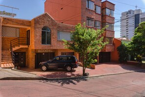 A building with a sign reading "ACODAL" and a parked SUV. - C A L Suites (Cali)