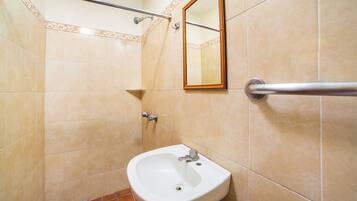 Un baño con lavabo, espejo y barra de apoyo.