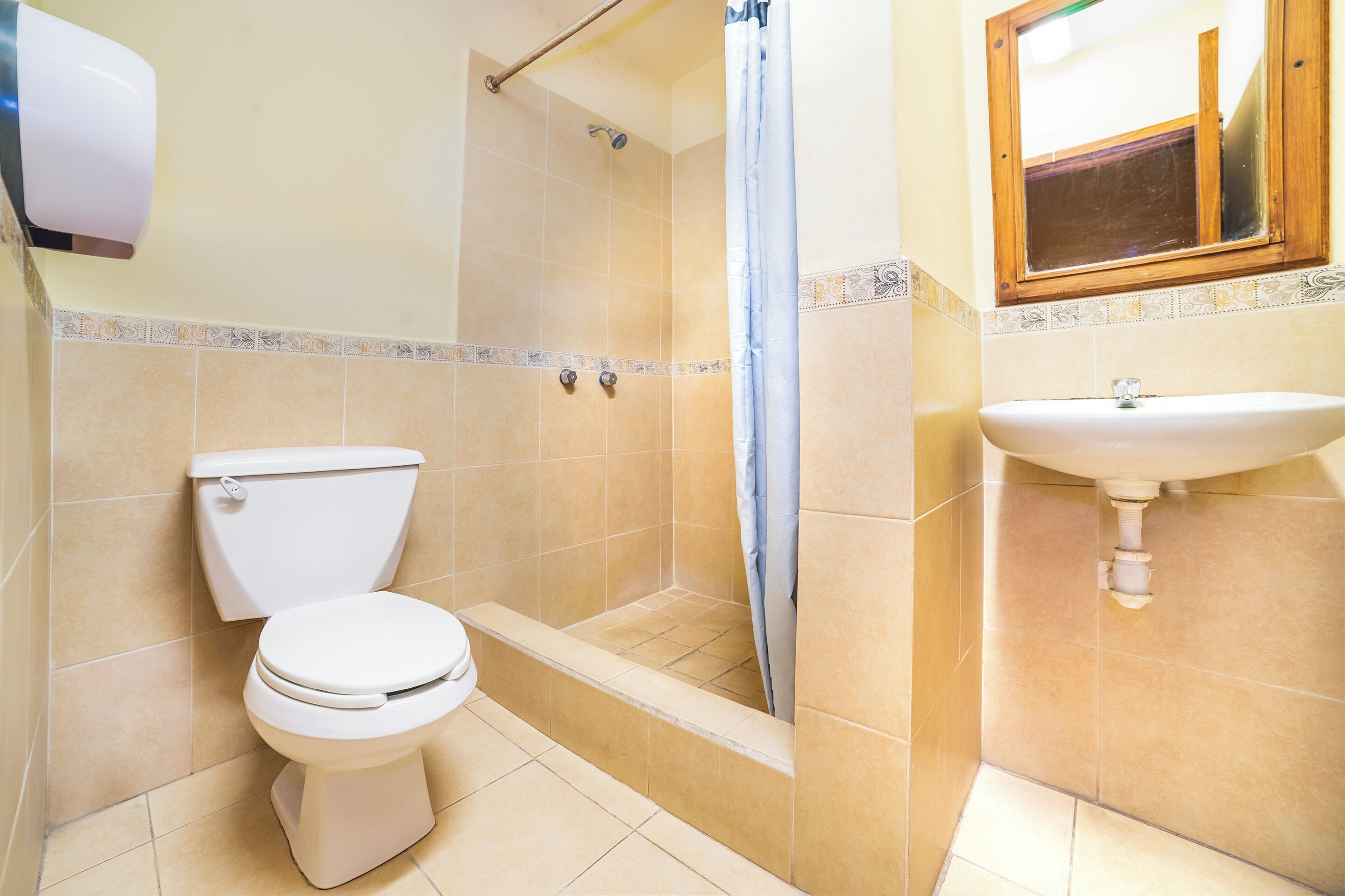 Un baño con inodoro, ducha y lavamanos.