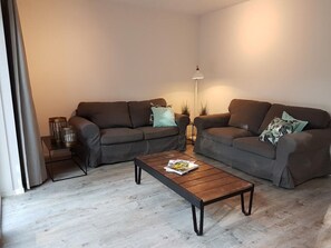 A modern living room with two sofas, a coffee table, and a floor lamp.