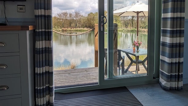Una habitación con puerta corrediza de vidrio que da a un patio junto al lago.