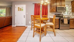 Una cocina compacta con armarios de madera, un microondas integrado y una estufa.