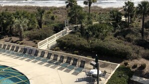 Un espace piscine doté de chaises longues et offrant une vue sur l’océan.