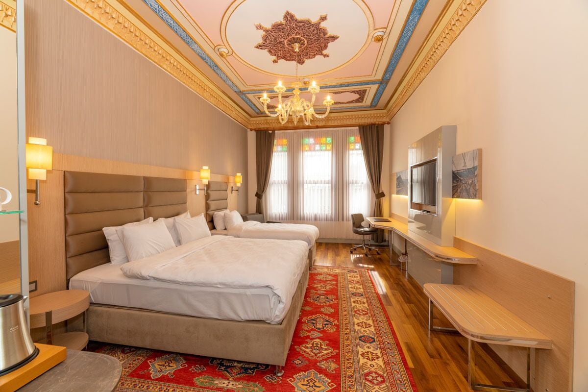 Deluxe Triple Room | Minibar, in-room safe, desk, laptop workspace