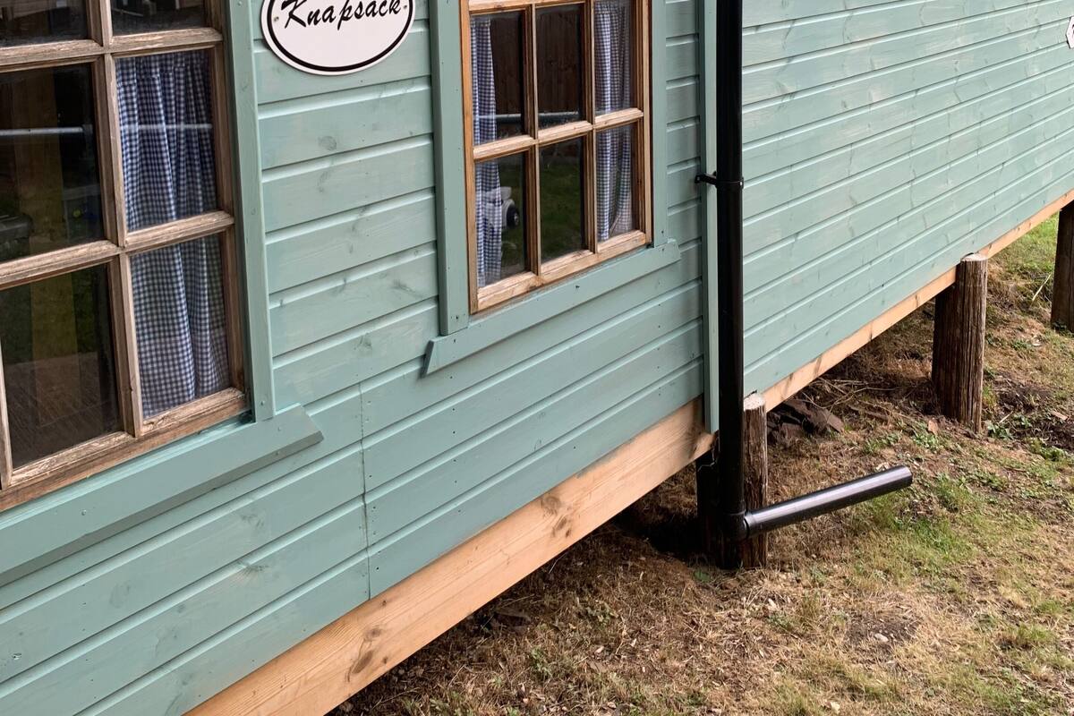Ein Gebäude mit einem Schild, auf dem 'Knapsack' steht, und einem Fenster mit einem Karottenmuster-Vorhang.