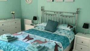 A bedroom with a bed, nightstands, a dresser, and a wall clock. - BedrockLodge Buisness Centre HolidayLets (Bristol)