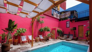 A swimming pool area with lounge chairs and potted plants. -  Hotel Boutique Casa de Arte (Oaxaca)