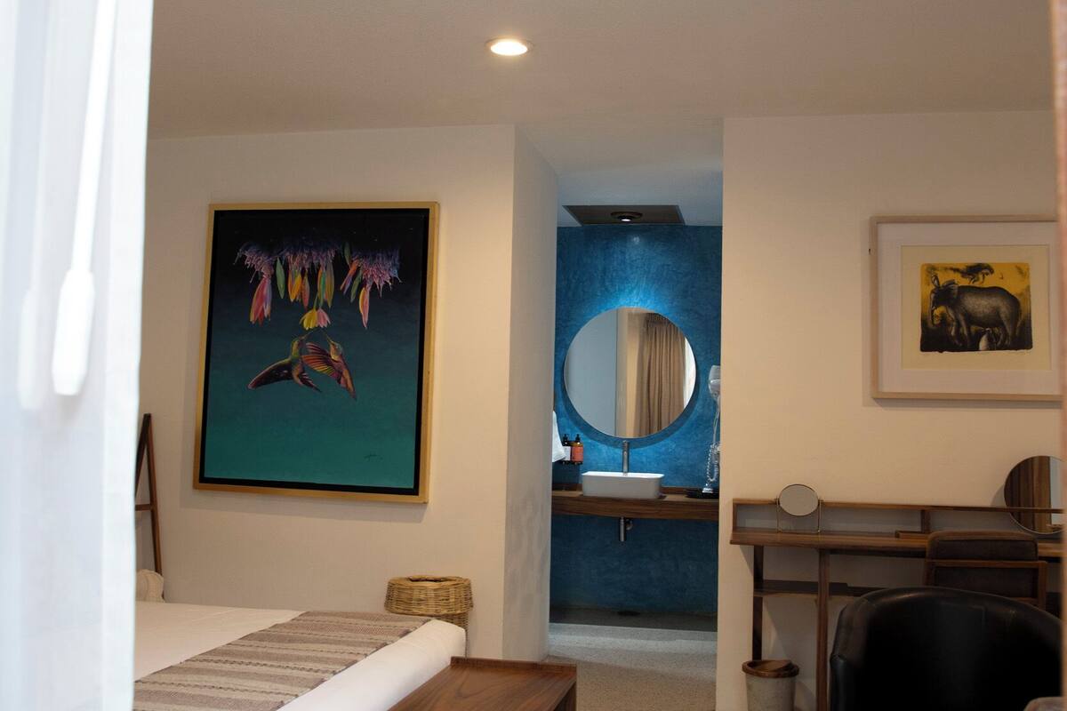 Ein Schlafzimmer mit einem Bett, einer hölzernen Bank, einem Schreibtisch und einem Stuhl.