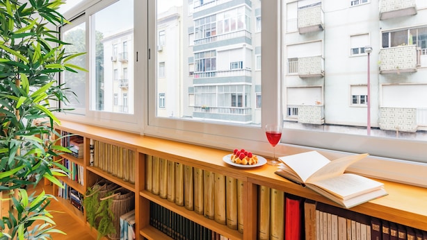 A room with a large window, a bookshelf, and a plate of fruit. - ShôLubi - Charming Quiet & Cozy (Lisbon)