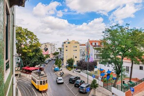 Une rue où l’on voit un tramway, des voitures garées et des immeubles dotés de balcons.