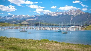 Marina con barcos amarrados, rodeada de montañas y cielos despejados.