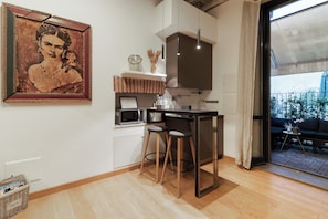 Une cuisine moderne équipée d’un four à micro-ondes, d’une machine à café et d’un tabouret de bar.