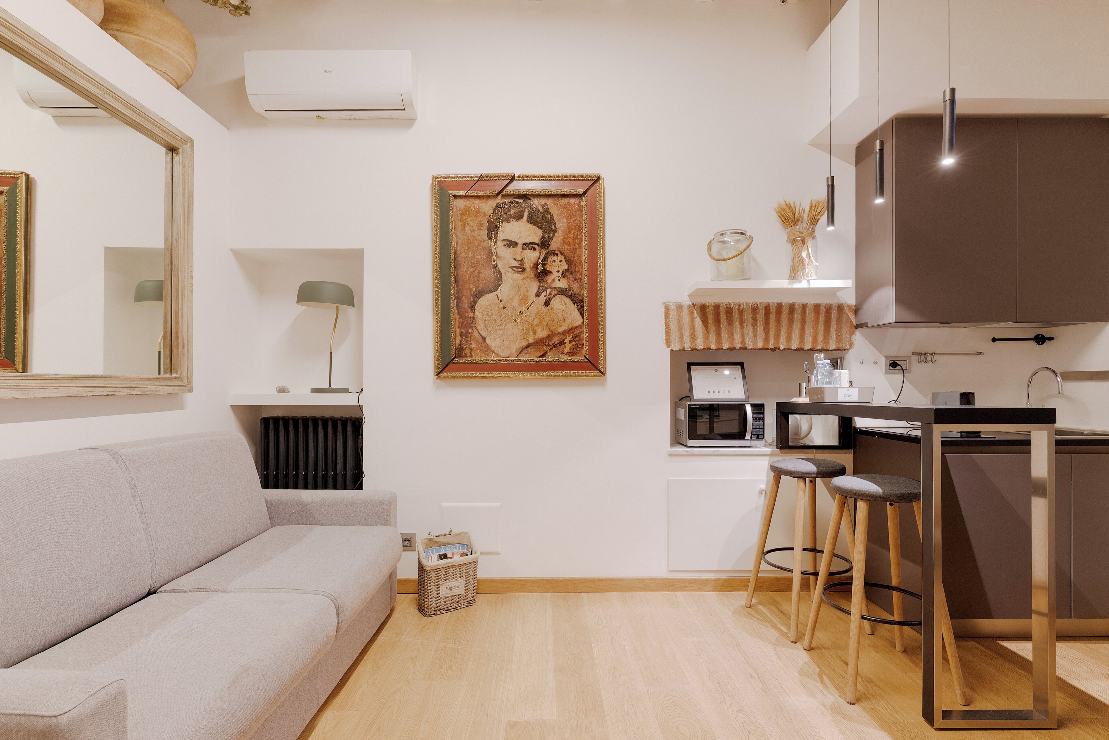 A modern kitchen with a bar stool, a microwave, and a coffee machine.