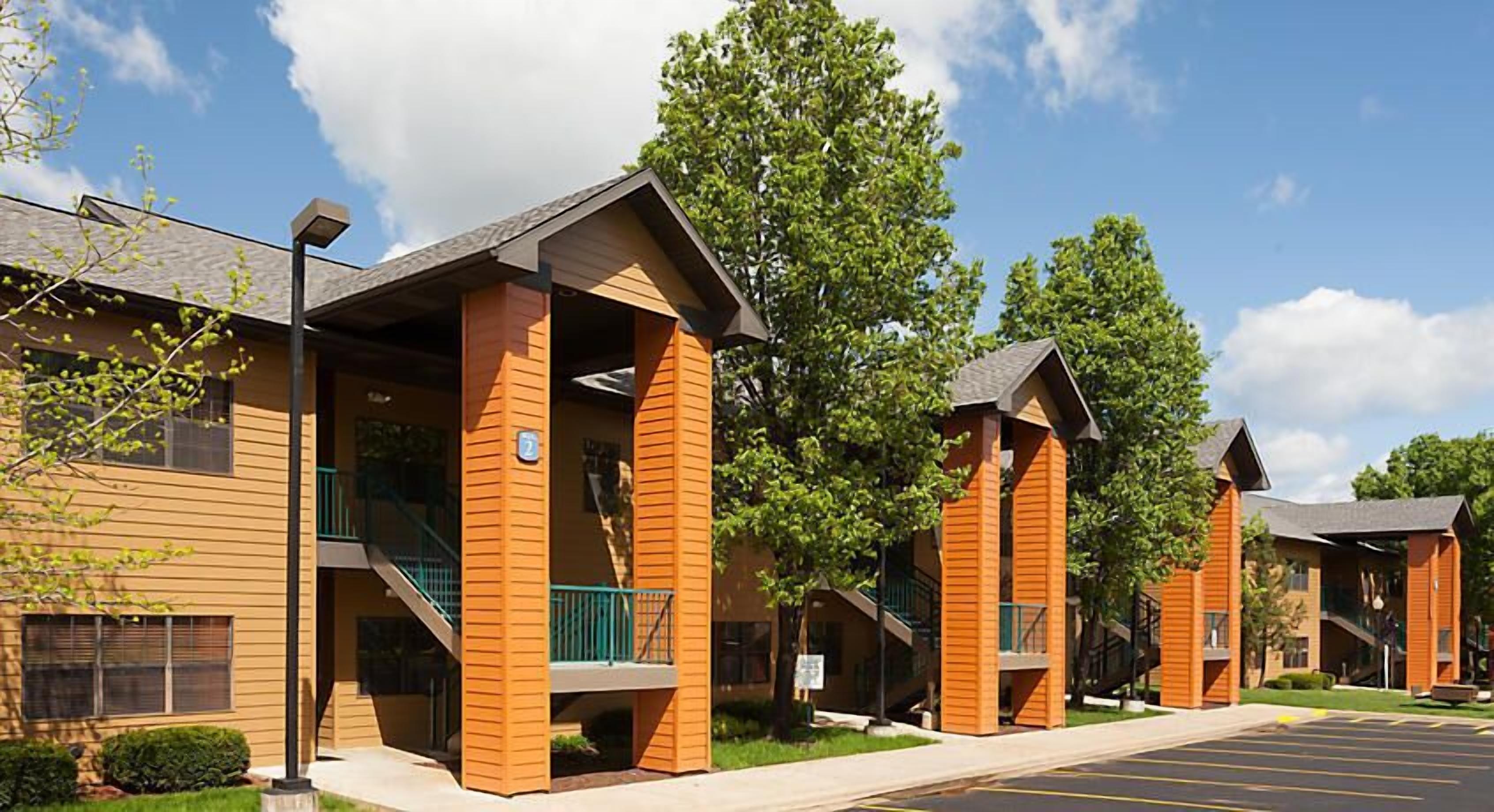A row of modern buildings with a uniform architectural style, featuring balconies and a clear sky.
