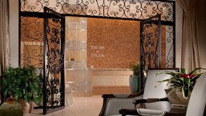 Zona de recepción con diseño moderno, que incluye mostrador de recepción, área de descanso y plantas decorativas.