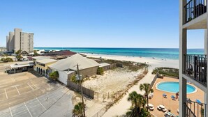 A beachfront hotel with a pool, beach access, and a view of the ocean.