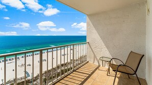Ein Balkon mit Blick auf Strand und Meer.