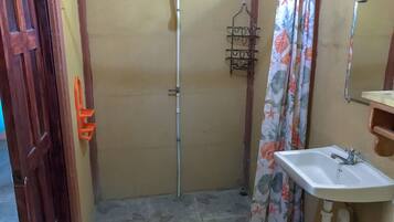 A bathroom with a shower, a sink, and a mirror.