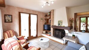 A living room with a fireplace, a television, and a sofa.