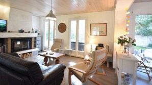 A cozy living room with a fireplace, comfortable seating, and a dining area.