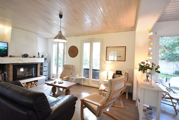 Een gezellige woonkamer met een open haard, comfortabele zitplaatsen en een eethoek.