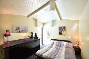 A bedroom with a bed, a dresser, a lamp, and a Buddha statue. - Hossegor “Thaïs”, Pleasant villa with swimming pool for 8 people. (Soorts-Hossegor)