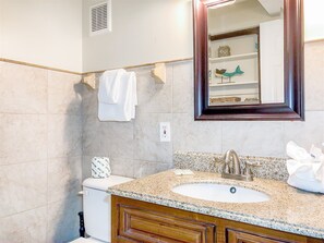 A bathroom with a white sink, wooden vanity, and a mirror. - The Summit 105 (Panama City Beach)