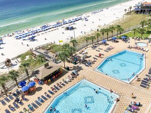 A beach resort with two swimming pools, sun loungers, and beach umbrellas. - The Summit 105 (Panama City Beach)