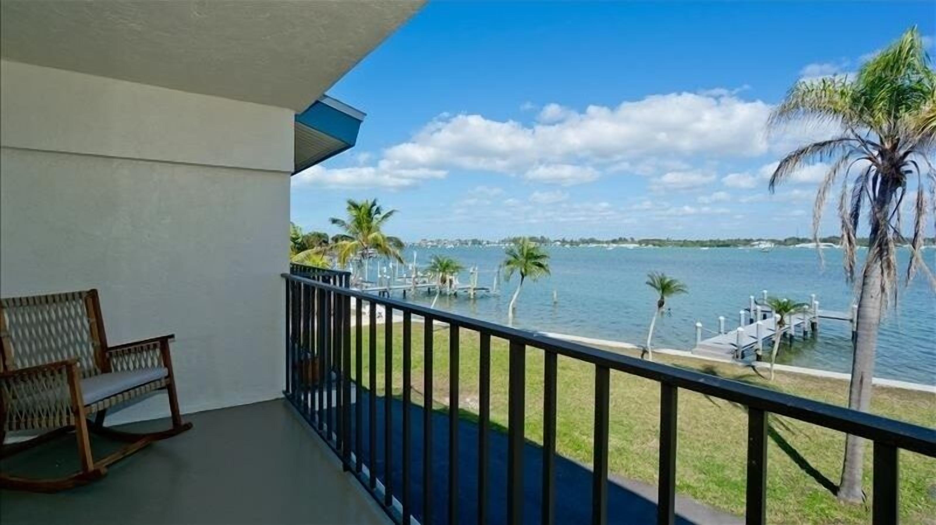 A balcony with a view of a marina and palm trees.