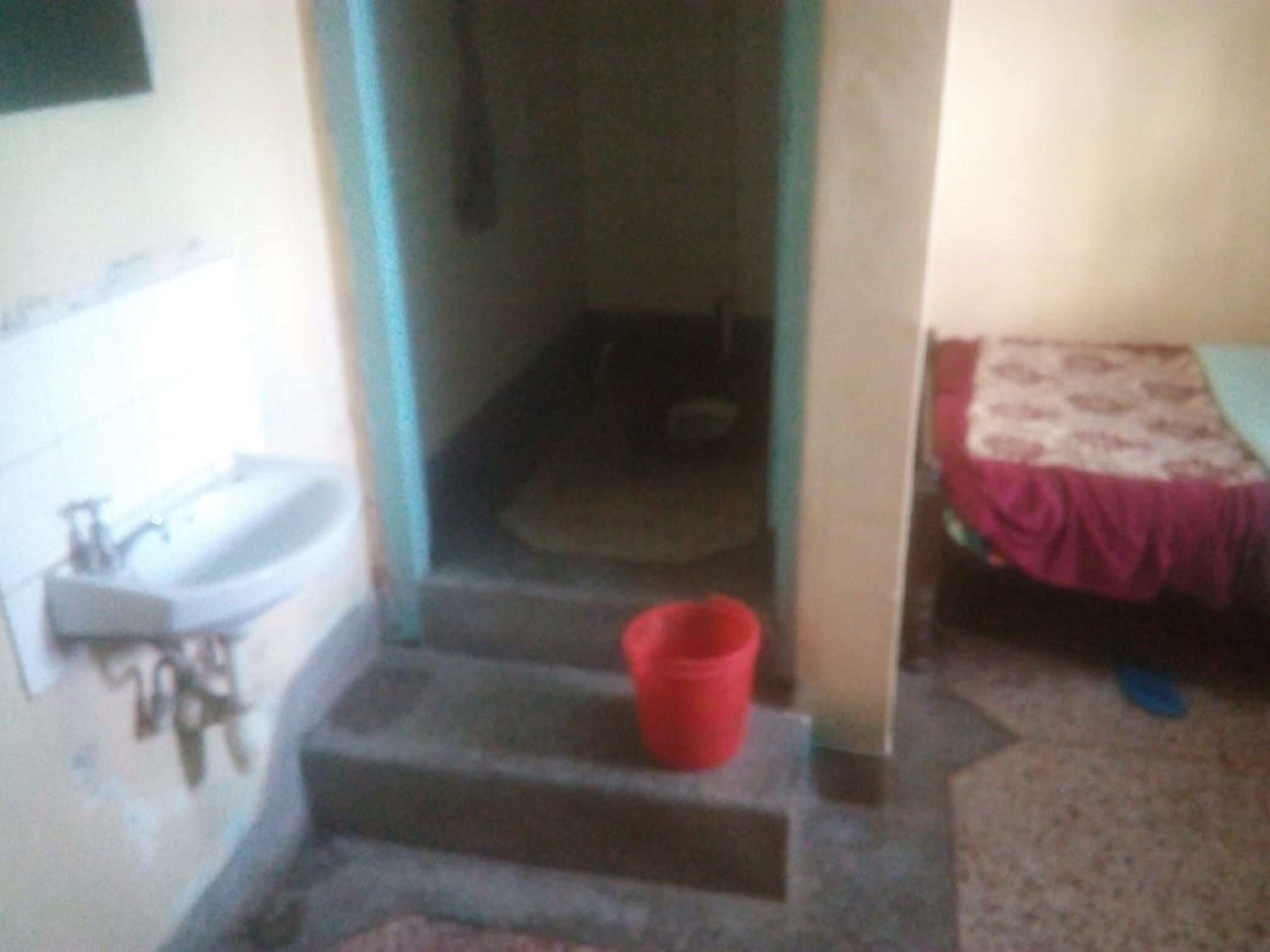 Una stretta scala conduce a una stanza con un letto e un piccolo lavandino.