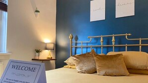 A neatly made bed with a sign that reads "WELCOME" and a message below it.