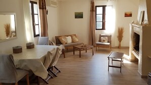 Ein gemütliches Wohnzimmer mit Sofa, Couchtisch und Kamin.