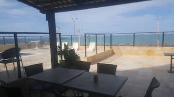 Apartment, Beach View, Oceanfront | Living area | Flat-screen TV