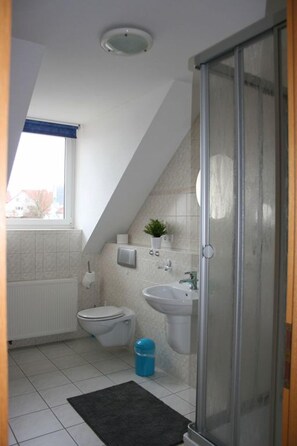 Studio suite | Badkamer | Een douche, een haardroger, handdoeken, zeep