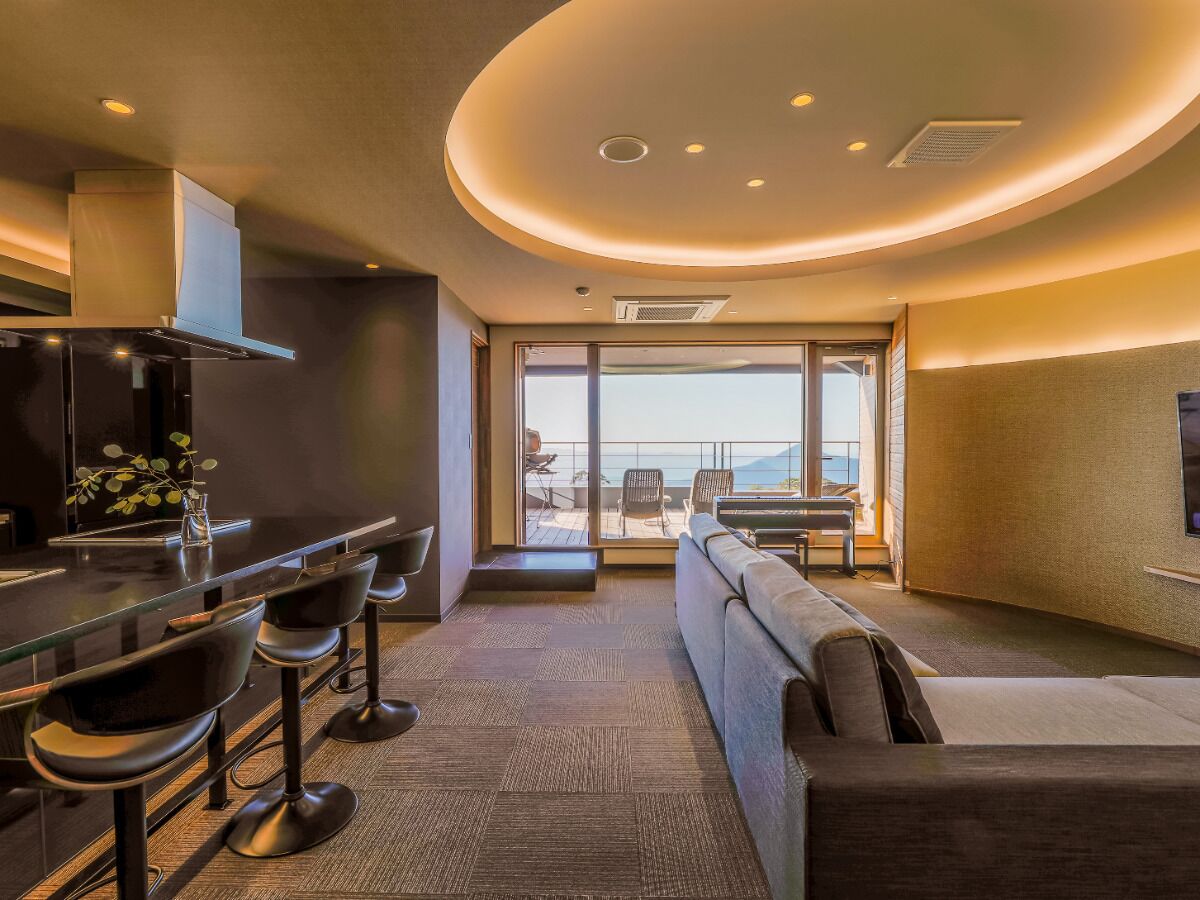 A modern interior with a bar area, seating, and a large window offering a view.