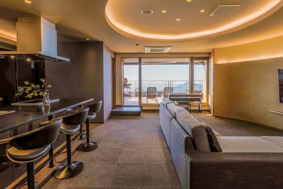 A modern interior with a bar area, seating, and a large window offering a view.