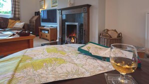 Une carte, un verre de vin et une cheminée dans un salon confortable.