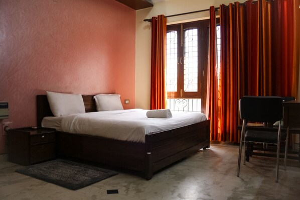 Un dormitorio con una cama, un escritorio y una silla.