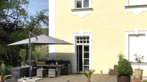 En uteplats med utemöbler, en pergola och krukväxter.