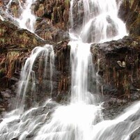 Una cascada que se precipita sobre rocas.
